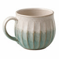 Tasse en céramique verte avec motif rayé